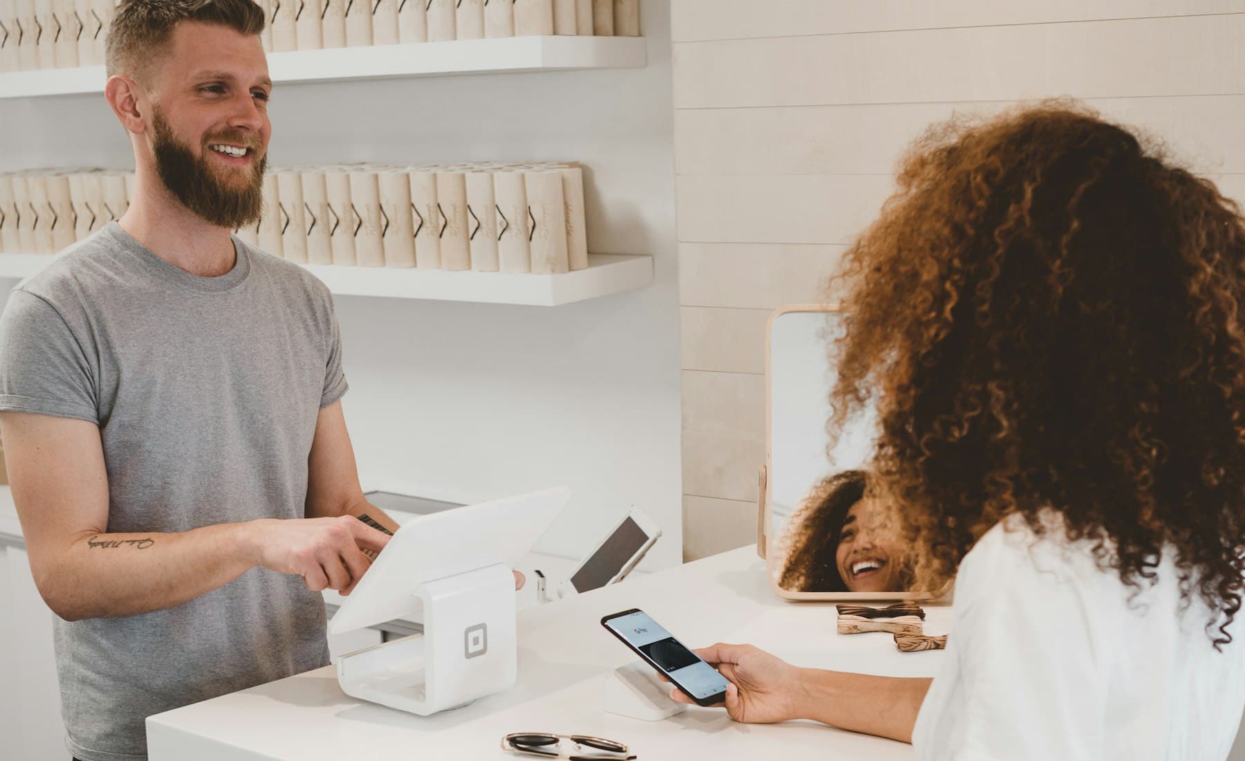 A merchant and a customer at a shop counter completing a card payment